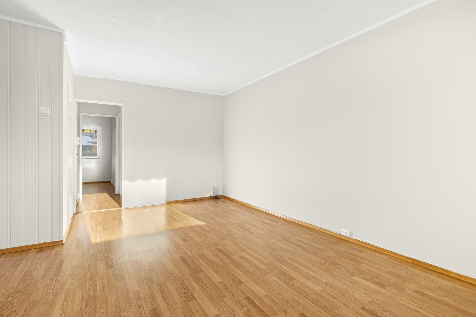 Empty rental living room with wood floors and afternoon light, cleaned and waiting between tenants