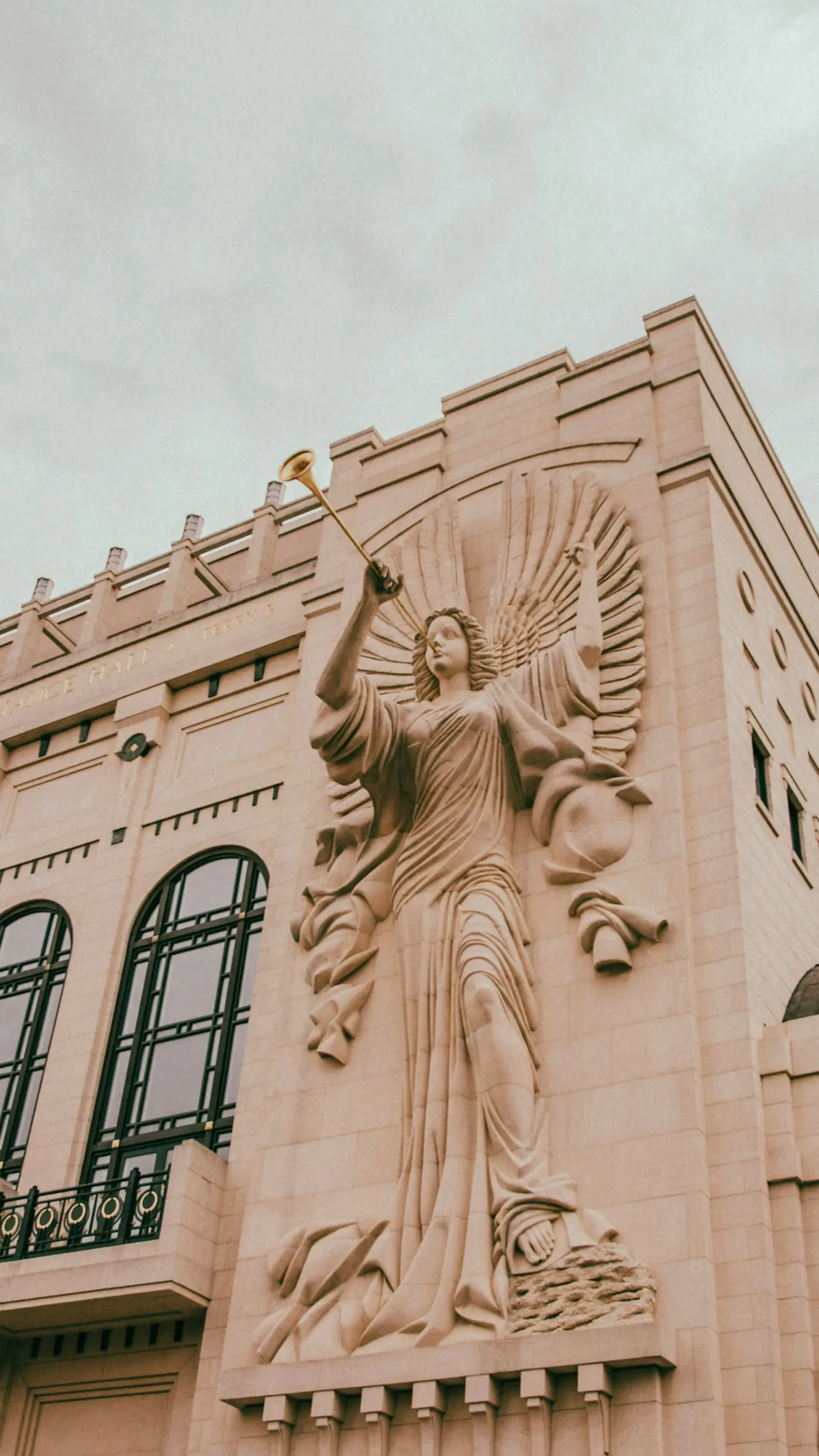 Stone angel figure with a raised trumpet on a Fort Worth building facade