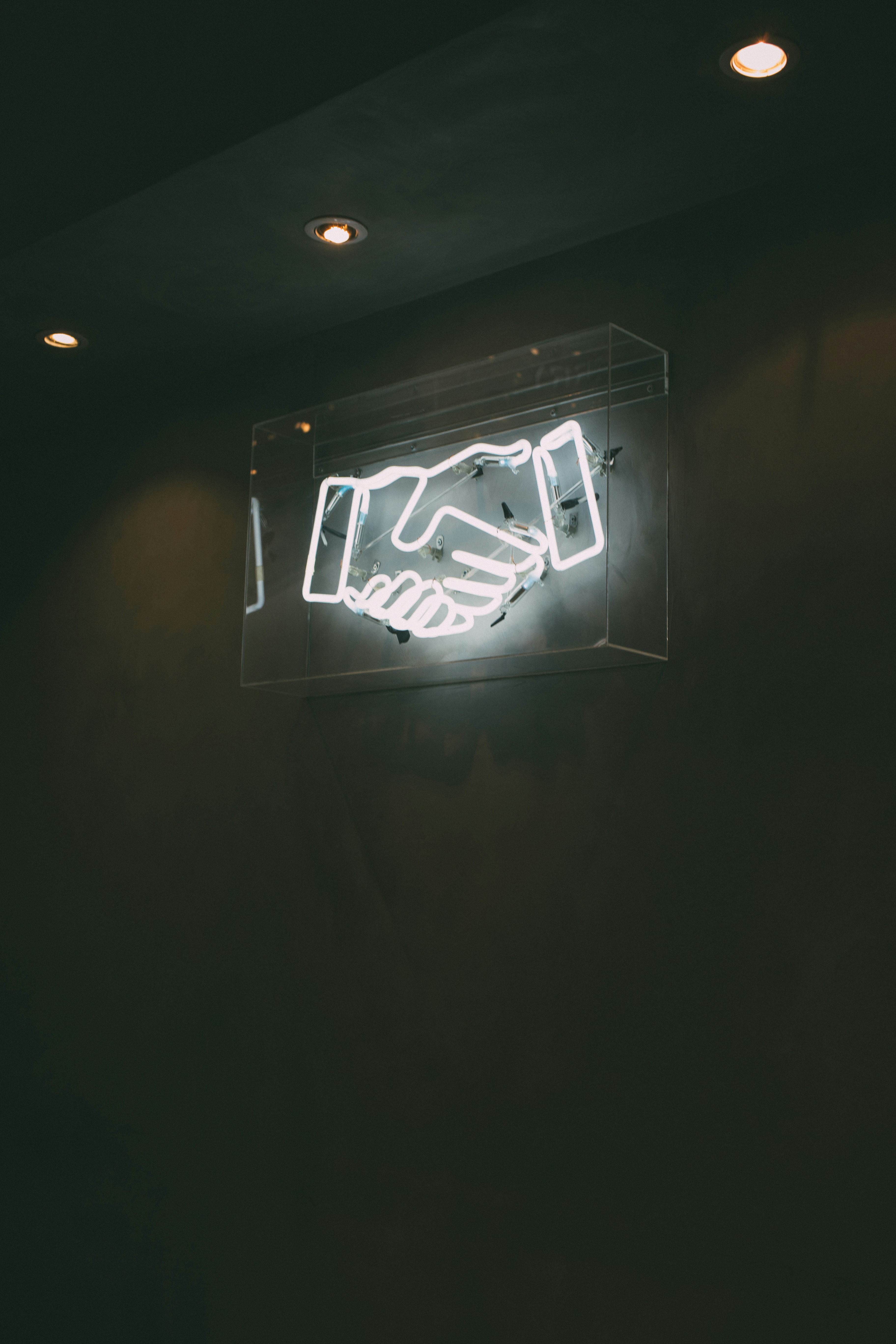 Neon handshake sign representing agreement between parties